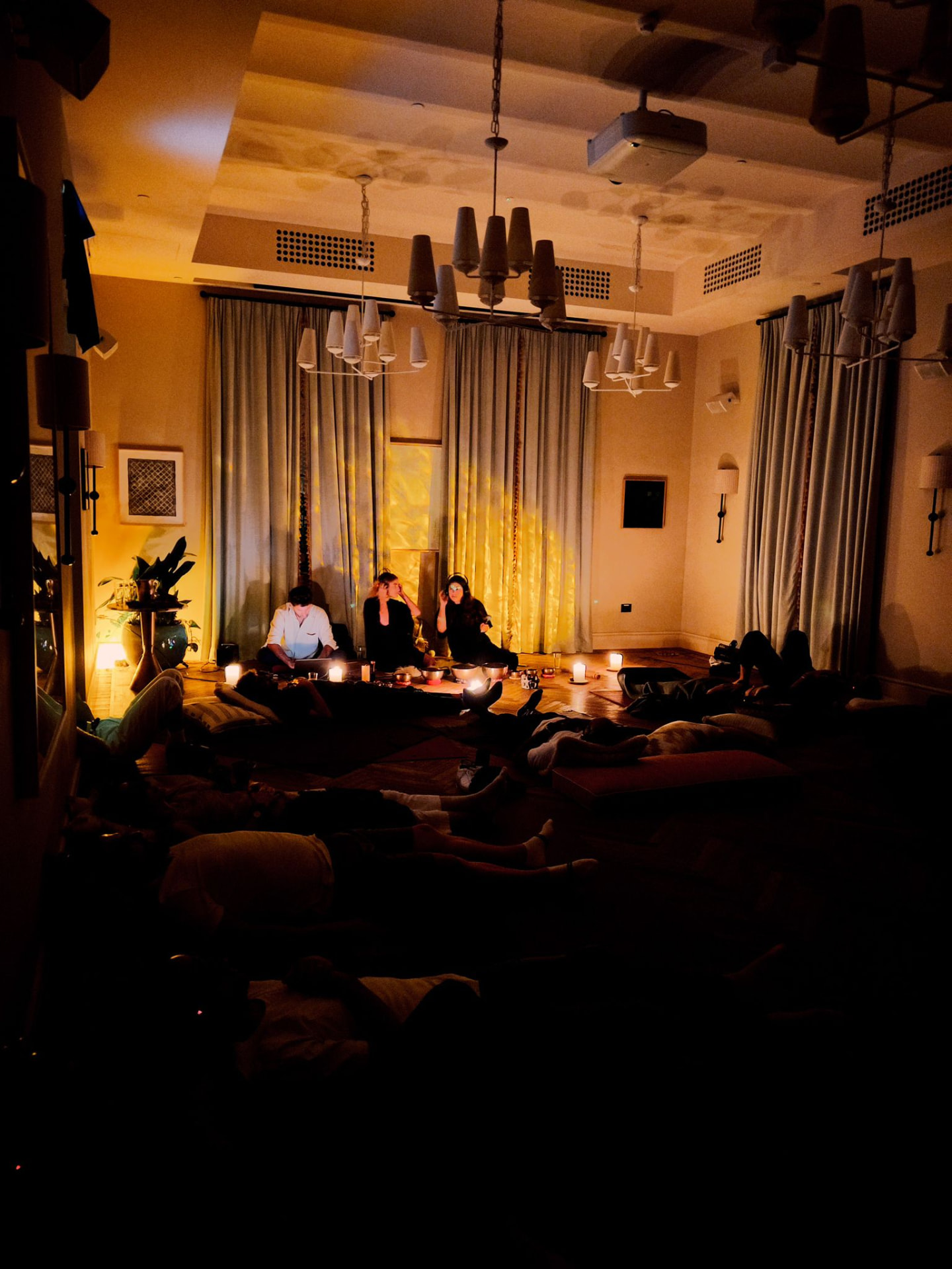 Goni setting up singing bowls and candles in a softly lit room