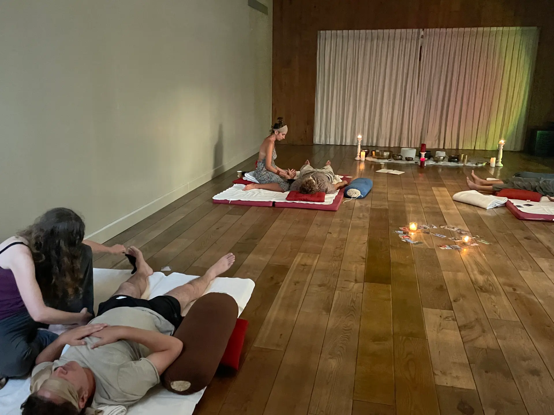 Goni setting up singing bowls and candles in a softly lit room