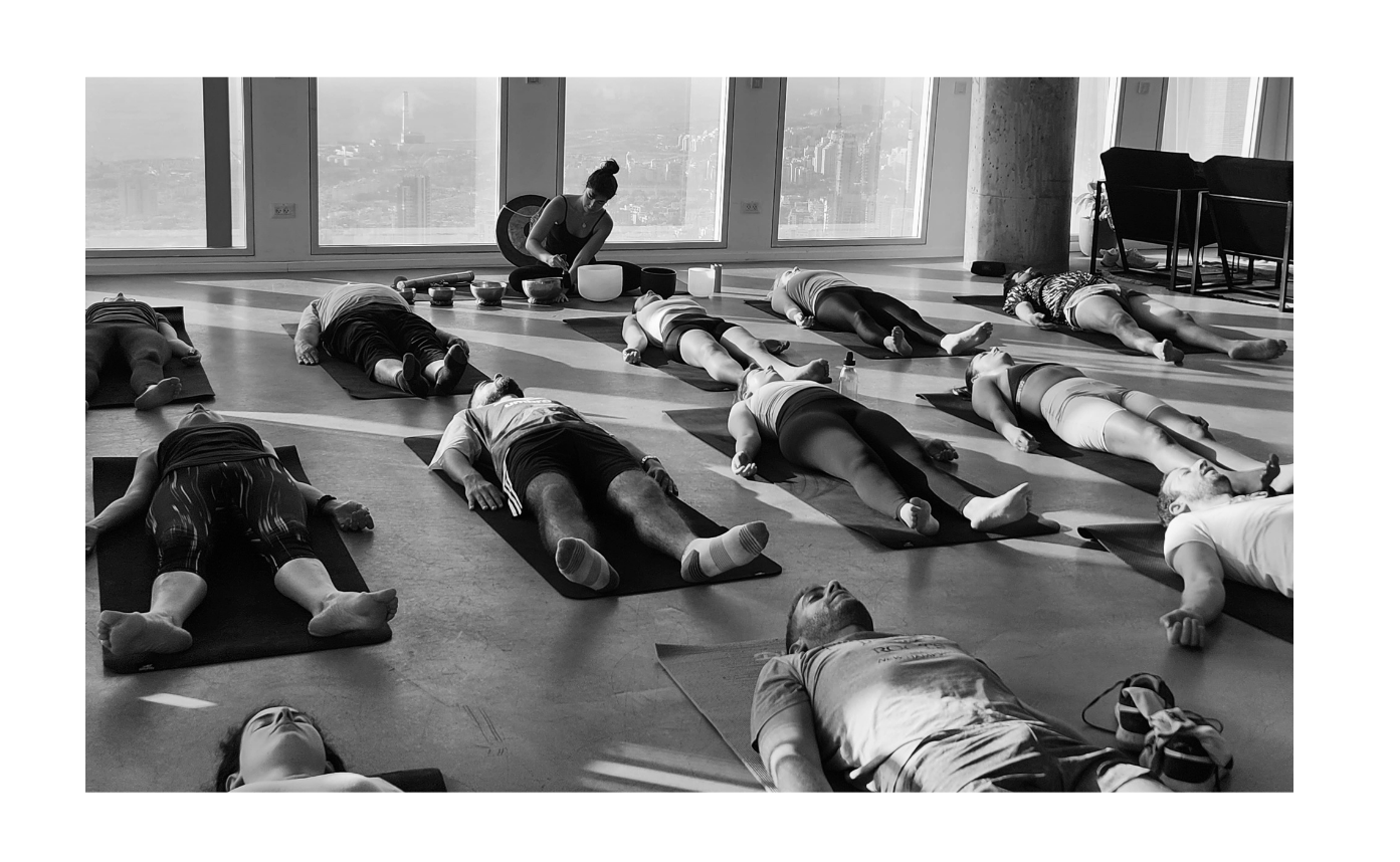 A group resting in savasana during a workshop