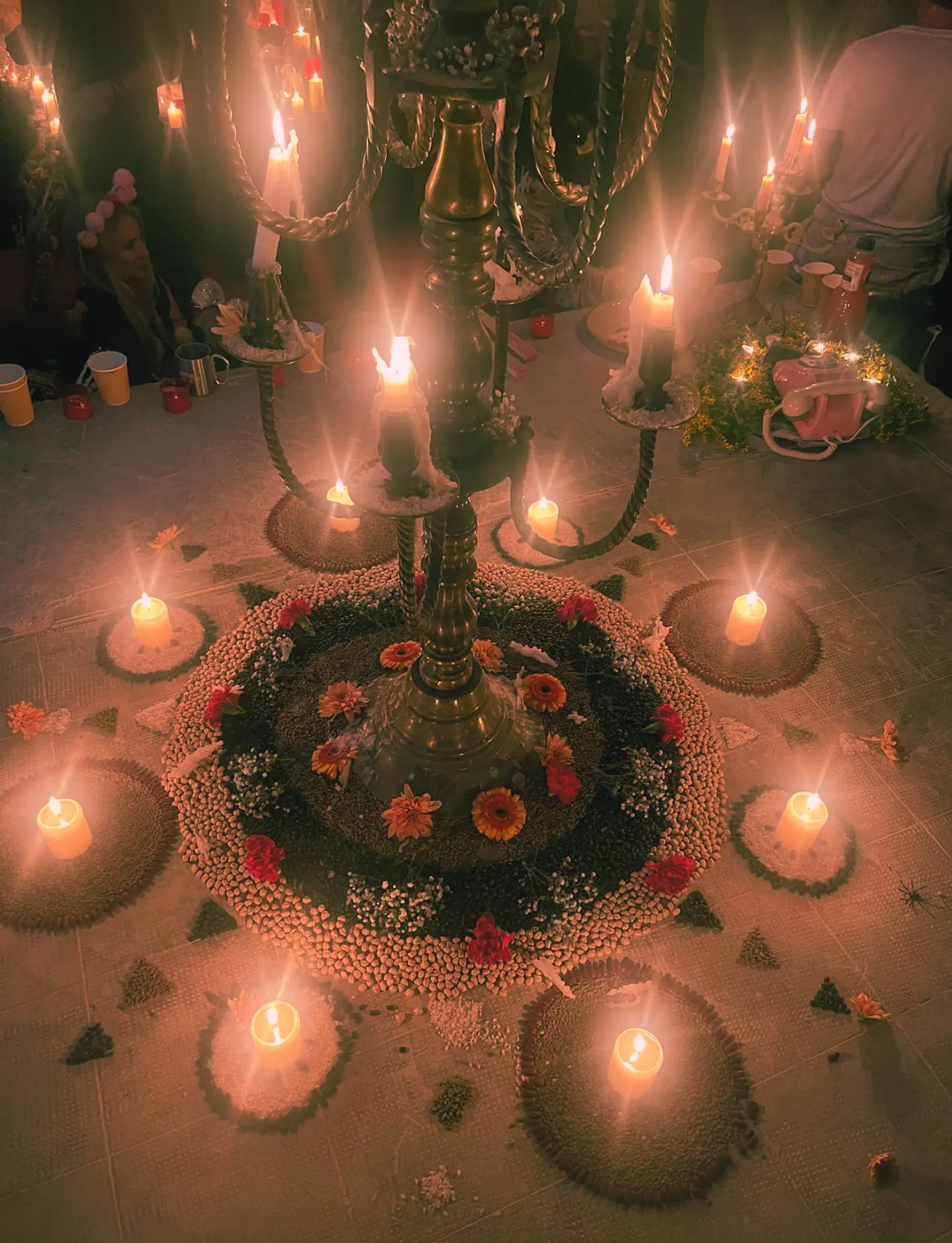 Goni setting up singing bowls and candles in a softly lit room